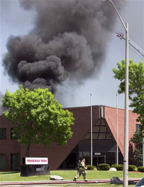 A firefighter runs in front of the Thinkway Toys Division building in Markham, Ontario, after an aircraft crashed into the roof of the building on Tuesday.